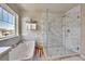 Bright bathroom features a soaking tub and a glass-enclosed shower with marble tiling at 24316 E Ottawa Ave, Aurora, CO 80016
