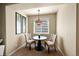 Cozy dining area with a round table, two chairs, a chandelier, and natural light from the window at 24316 E Ottawa Ave, Aurora, CO 80016