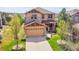 Charming two-story home showcasing a well-manicured front lawn, a two-car garage, and stone accents at 24316 E Ottawa Ave, Aurora, CO 80016