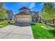 Inviting two-story home featuring a two-car garage, stone accents, and a beautifully landscaped front yard at 24316 E Ottawa Ave, Aurora, CO 80016