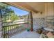 Inviting covered front porch with stone pillars, a wooden railing and charming decor at 24316 E Ottawa Ave, Aurora, CO 80016