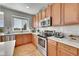 Updated kitchen with stainless steel appliances, white counters, and wood cabinets at 24316 E Ottawa Ave, Aurora, CO 80016