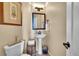 Elegant powder room featuring pedestal sink, decorative mirror, and neutral color scheme at 24316 E Ottawa Ave, Aurora, CO 80016