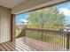 Apartment balcony with wood floor and view of lush green trees at 3663 S Sheridan Blvd # J12, Denver, CO 80235