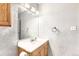 Well-lit bathroom featuring a large mirror, textured walls and wooden vanity at 3663 S Sheridan Blvd # J12, Denver, CO 80235