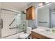 Bright bathroom features a shower-over-bath with glass screen and a classic wood vanity at 3663 S Sheridan Blvd # J12, Denver, CO 80235