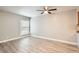 Open bedroom space offers wood-look floors, a ceiling fan, and bright window at 3663 S Sheridan Blvd # J12, Denver, CO 80235