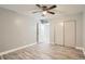 Bedroom features wood floors, neutral gray walls, ceiling fan, and ample closet space at 3663 S Sheridan Blvd # J12, Denver, CO 80235