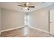 Bright bedroom featuring wood-look floors, neutral gray walls, and a ceiling fan at 3663 S Sheridan Blvd # J12, Denver, CO 80235
