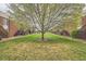 Exterior view of complex with lush green lawn and large shade tree at 3663 S Sheridan Blvd # J12, Denver, CO 80235