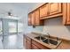 Cozy kitchen with light gray walls, wood cabinets, stainless steel sink and modern fixtures at 3663 S Sheridan Blvd # J12, Denver, CO 80235