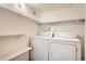 Laundry room complete with a washer, dryer, and storage shelves at 3663 S Sheridan Blvd # J12, Denver, CO 80235