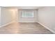 Spacious empty living room with sleek, light-colored flooring and a large window at 3663 S Sheridan Blvd # J12, Denver, CO 80235