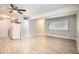 Open living room with hardwood-style floors, ceiling fan, and natural light from a large window at 3663 S Sheridan Blvd # J12, Denver, CO 80235