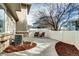 Back patio with seating area, mulch landscaping and white vinyl fence at 10141 Autumn Blaze Trl, Highlands Ranch, CO 80129