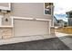 Two car garage with brick and siding exterior at 10141 Autumn Blaze Trl, Highlands Ranch, CO 80129