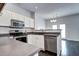 Bright kitchen showcasing stainless steel appliances, dark flooring, and view to dining area at 10141 Autumn Blaze Trl, Highlands Ranch, CO 80129
