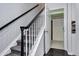 Carpeted staircase featuring a dark handrail and white risers, near an open doorway at 10141 Autumn Blaze Trl, Highlands Ranch, CO 80129