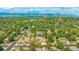 Stunning aerial view shows neighborhood lush with mature trees and mountain views at 7591 S Reed Ct, Littleton, CO 80128