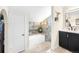 Modern bathroom showcasing a soaking tub with gray tile surround and a sleek vanity at 7591 S Reed Ct, Littleton, CO 80128