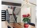 Dining room featuring a modern light fixture and view of staircase with black metal railing at 7591 S Reed Ct, Littleton, CO 80128
