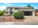 Charming two-story home with a modern garage door, well-maintained lawn, and fresh landscaping at 7591 S Reed Ct, Littleton, CO 80128