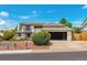 Two-story home featuring a modern garage door, balcony, and fresh landscaping enhancing the curb appeal at 7591 S Reed Ct, Littleton, CO 80128