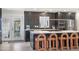 Modern kitchen featuring an island with seating and sleek, dark cabinetry with stainless steel appliances at 7591 S Reed Ct, Littleton, CO 80128