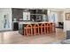 Modern kitchen boasts sleek black cabinetry, stainless steel appliances, and a spacious island with unique seating at 7591 S Reed Ct, Littleton, CO 80128