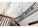 Interior staircase design with wooden handrail, black metal accents, and modern lighting at 7591 S Reed Ct, Littleton, CO 80128