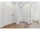 Bright hallway featuring wood floors, white doors, and a view into other rooms at 9692 Cathay St, Commerce City, CO 80022