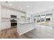 Modern kitchen with stainless steel appliances, white cabinetry, and a large center island at 9692 Cathay St, Commerce City, CO 80022