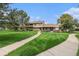 Townhome exterior featuring a beautiful green lawn and sidewalk at 9031 E Amherst Dr # D, Denver, CO 80231