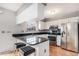 Modern kitchen with granite countertops, stainless steel appliances, and bar stool seating at 9031 E Amherst Dr # D, Denver, CO 80231