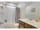Bright bathroom featuring shower-tub combo, white subway tile, and neutral vanity at 9373 Pitkin St, Commerce City, CO 80022