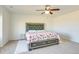 Bedroom with a floral patterned bedspread, ceiling fan, and rug, with neutral walls at 9373 Pitkin St, Commerce City, CO 80022