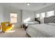 Bright bedroom featuring two beds and a sunny yellow chair by the window at 9373 Pitkin St, Commerce City, CO 80022