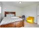 Comfortable bedroom with wood bed frame, upholstered armchair, and neutral walls at 9373 Pitkin St, Commerce City, CO 80022