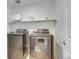 Modern laundry room with a front-load washer and dryer, and a shelf at 9373 Pitkin St, Commerce City, CO 80022