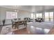 Open-plan living and dining area with large windows and sliding glass doors to the balcony at 9373 Pitkin St, Commerce City, CO 80022