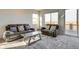 Bright living room with comfortable seating and access to a balcony with scenic views at 9373 Pitkin St, Commerce City, CO 80022
