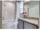Bright bathroom with a granite-topped vanity, a shower over tub, and a decorative orchid at 16578 E 111Th Pl, Commerce City, CO 80022