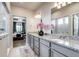 Bathroom featuring dual sinks with granite countertops, vanity, and view to bedroom at 16578 E 111Th Pl, Commerce City, CO 80022