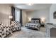 Comfortable bedroom with a checkered bedspread, a chair, and ample natural light at 16578 E 111Th Pl, Commerce City, CO 80022