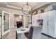 Bright home office featuring modern desk, chair, decorative chandelier, and stylish built-in storage cabinets at 16578 E 111Th Pl, Commerce City, CO 80022