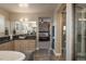 Bathroom showcasing double sinks, stylish vanity, walk-in shower and soaking tub at 237 Maplehurst Dr, Highlands Ranch, CO 80126