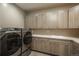 Well-equipped laundry room with modern washer/dryer and plenty of storage in cabinets at 237 Maplehurst Dr, Highlands Ranch, CO 80126