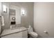 Chic powder room featuring modern lighting, stone tile, and a contemporary vanity at 237 Maplehurst Dr, Highlands Ranch, CO 80126