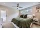 Cozy bedroom with plush green bedding, ceiling fan, and natural light from a wide window at 4455 Tejon St, Denver, CO 80211