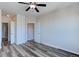 Spacious bedroom featuring two entryways, a ceiling fan, and wood-style flooring at 13456 Via Varra # 406, Broomfield, CO 80020
